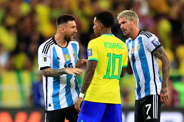 RIO DE JANEIRO, BRAZIL - NOVEMBER 21: Lionel Messi of Argentina (L) and teammate Rodrigo de Paul talk to Rodrygo of Brazil after the match was delayed due to incidents in the stands during a FIFA World Cup 2026 Qualifier match between Brazil and Argentina at Maracana Stadium on November 21, 2023 in Rio de Janeiro, Brazil. (Photo by Buda Mendes/Getty Images)
