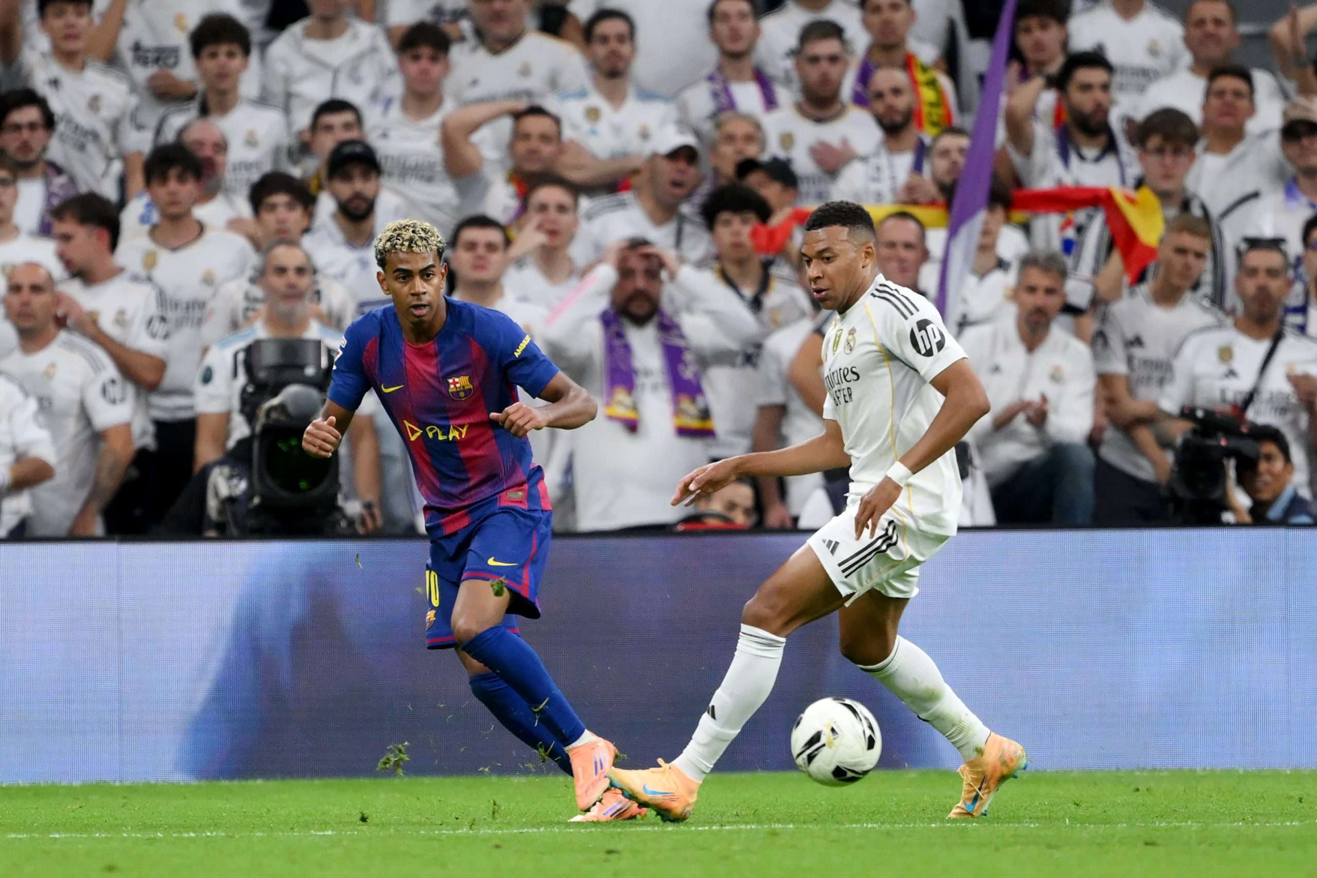 MADRID, SPAIN - OCTOBER 26: Lamine Yamal of FC Barcelona passes the ball whilst under pressure from Kylian Mbappe of Real Madrid during the LaLiga EA Sports match between Real Madrid CF and FC Barcelona at Estadio Santiago Bernabeu on October 26, 2025 in Madrid, Spain. (Photo by David Ramos/Getty Images)