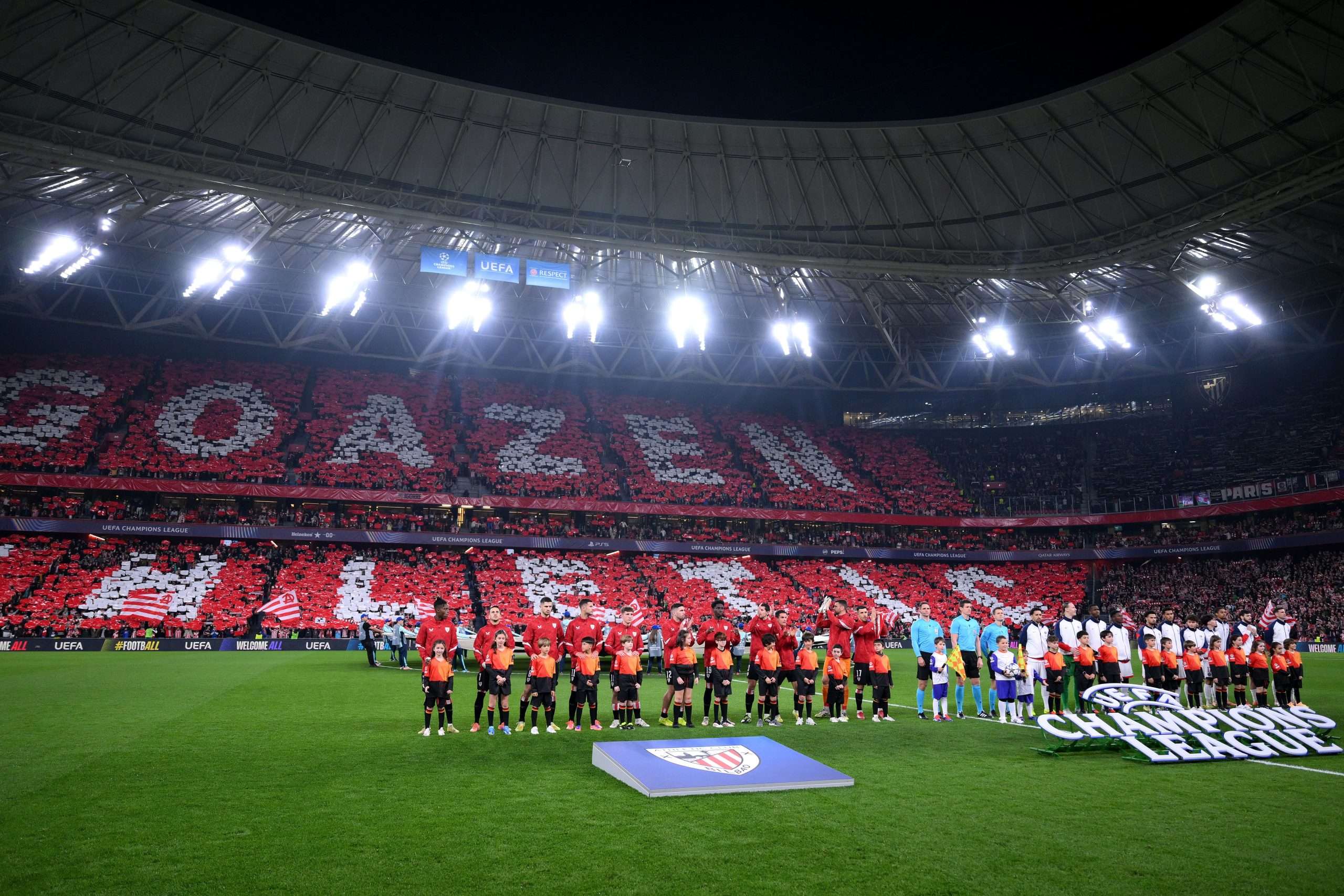 The teams, mascots and match officials applaud the fans as they line up prior to the UEFA Champions League 2025/26 League Phase MD6 match between Athletic Club and Paris Saint-Germain at Estadio de San Mames on December 10, 2025 in Bilbao, Spain. (Photo by David Ramos/Getty Images)